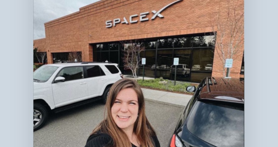Raleigh Woods posing with SpaceX sign