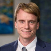 Headshot of Travis Kulpa in a suit and tie