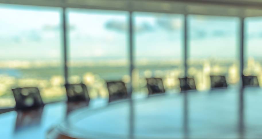 Unfocused image of a conference room with large windows