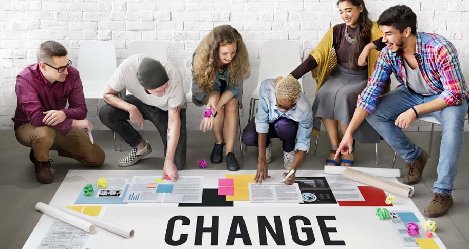 Group of young professionals working on project with "CHANGE" written across it