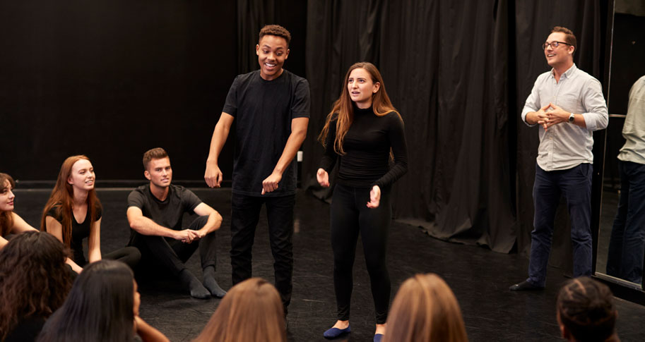 A group of students performing an improv skit in front of their peers. 