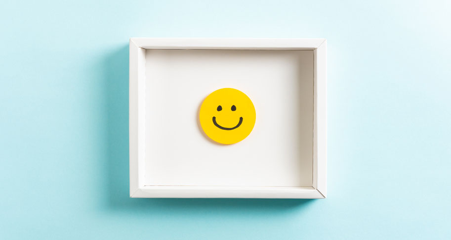 Yellow smiley face in a white frame on a blue background