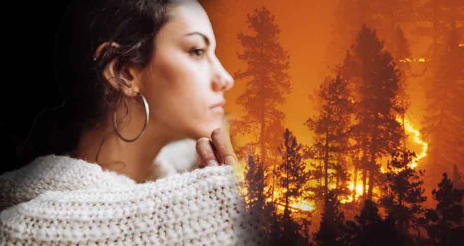 Woman looking out with a wildfire in the background