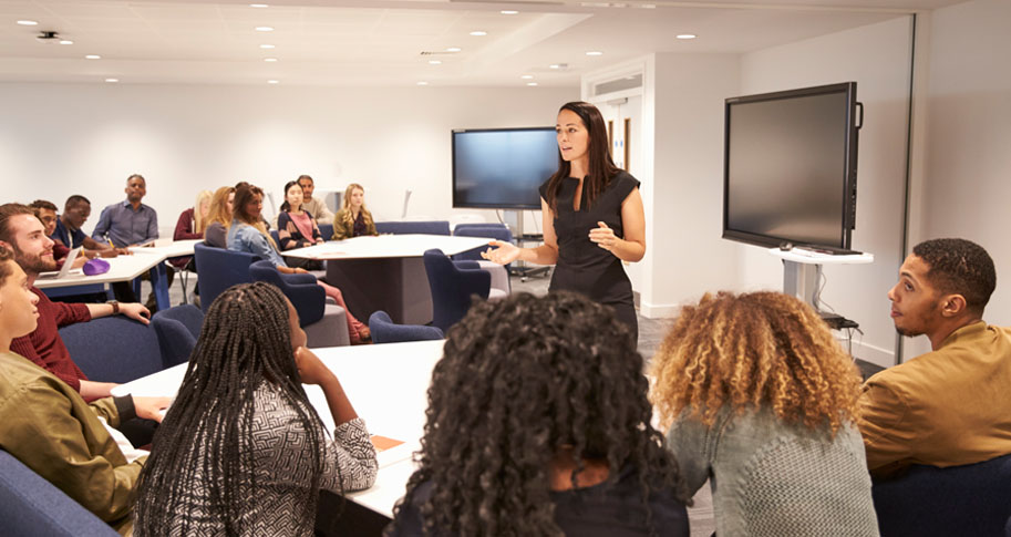 Female leader speaking to a medium sized room of people