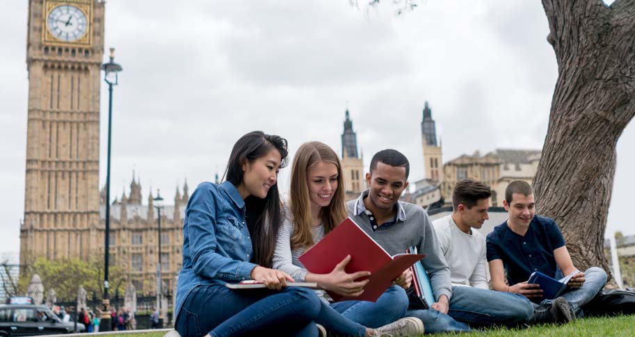 Students studying together in front of a clock tower.