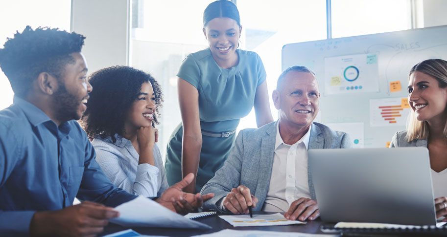 Information technology employees gather around a table to collaborate