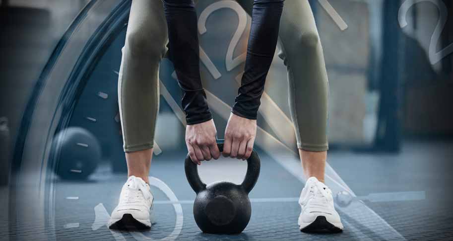 Women lifting a kettlebell with image of a stopwatch faded in the background