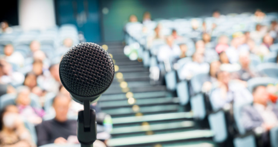 Microphone facing speaker in front of crowd of people