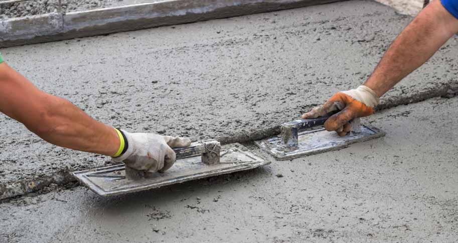 Two men working to smooth concrete 
