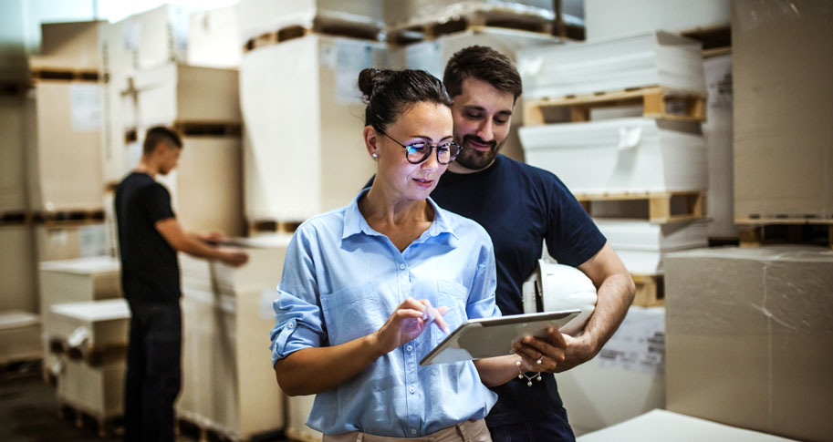 Woman and man looking at iPad in storage facility 