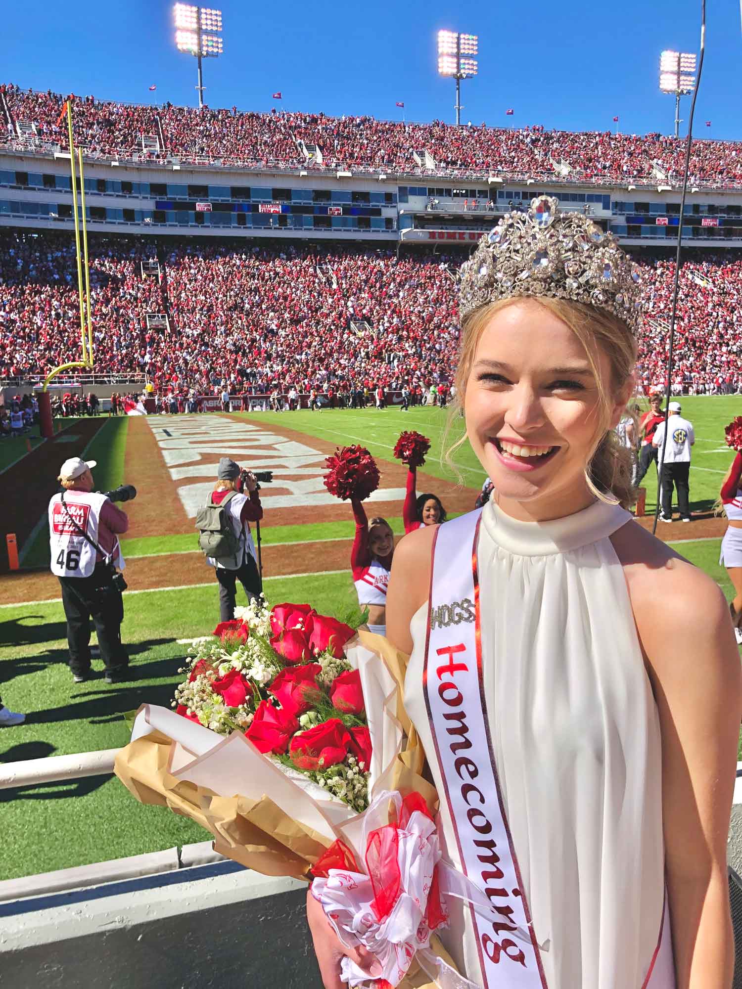 Grace Crain poses with football field on coronation day.
