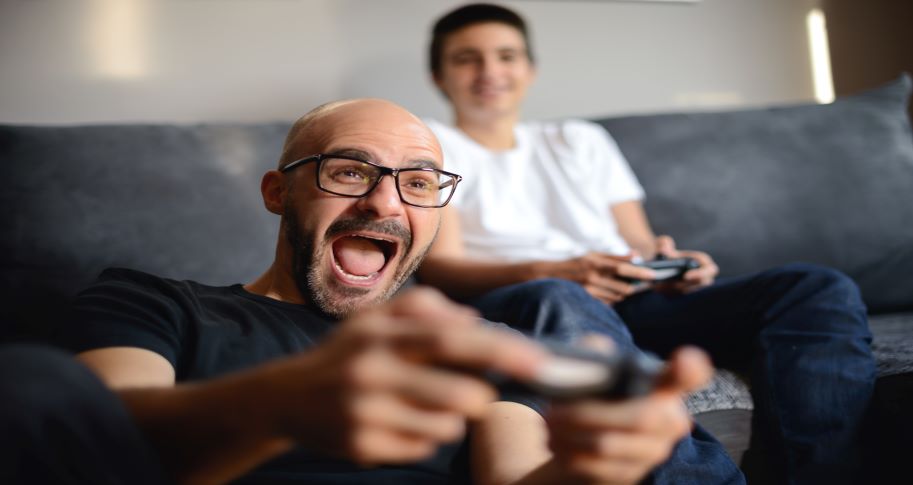 Happy man playing video games with his son.