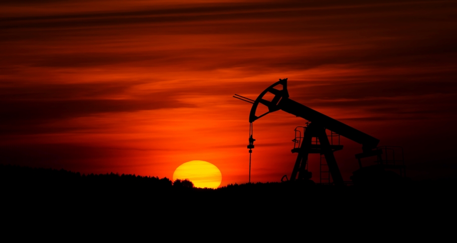 Oil drilling rig against the backdrop of a red sky at sunset