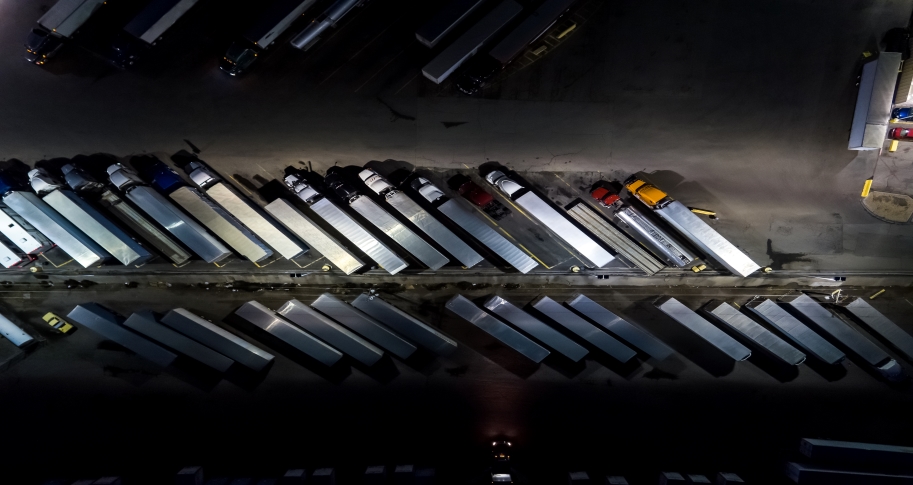 Overhead view of trucks parked at a rest stop at night.