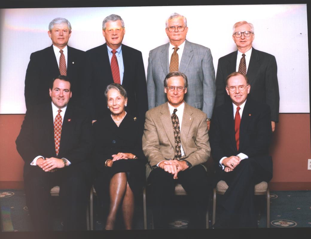 (Front row) Gov. Mike Huckabee, Helen Walton, Rob Walton, John A. White; (back row) Frank Oldham Jr., B. Alan Sugg, Curtis Shipley, Doyle Williams